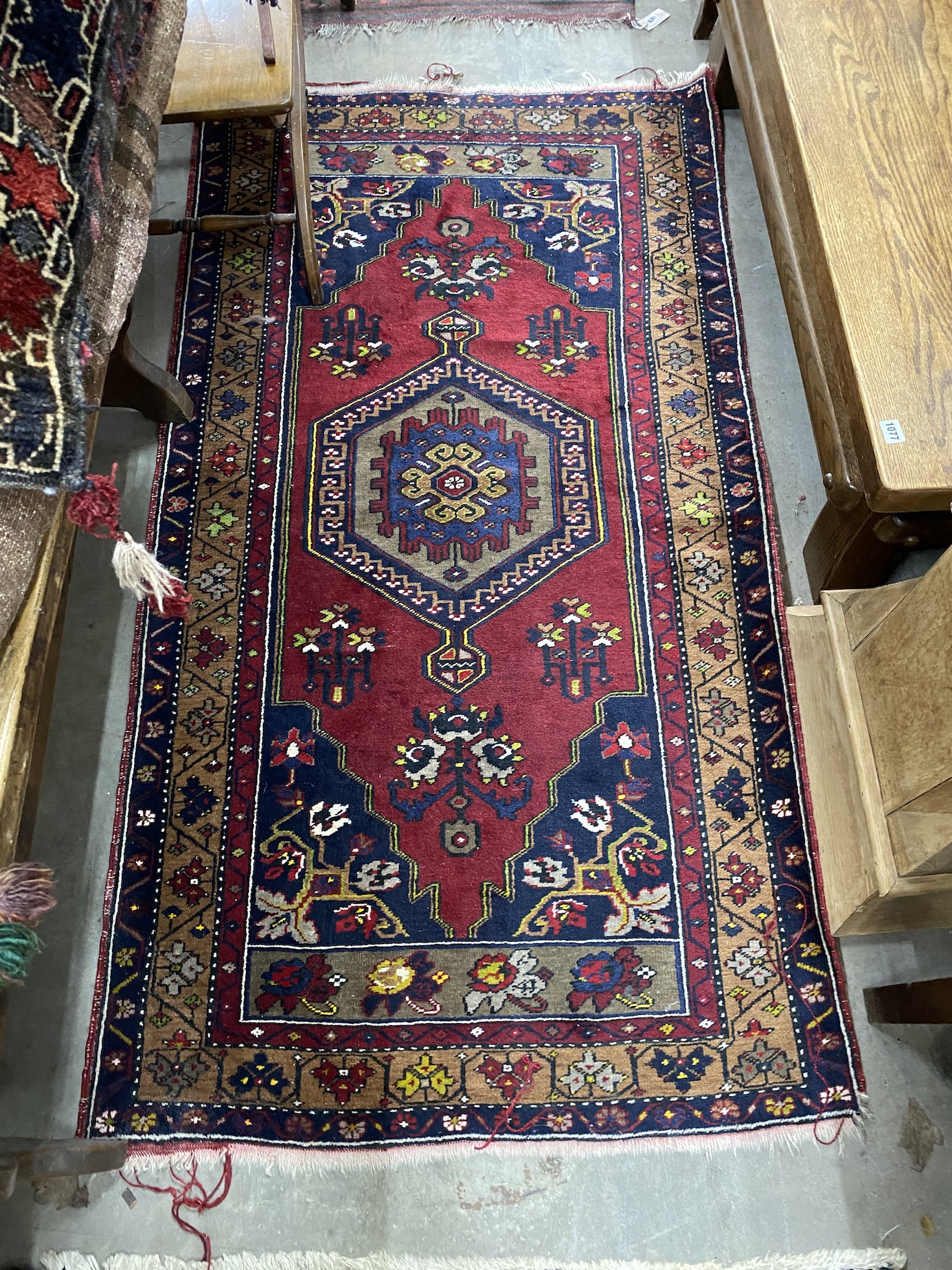 A Caucasian style burgundy ground rug and a North West Persian red ground rug, larger 194 x 106cm